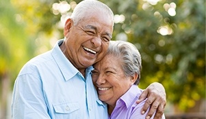 Older man and woman smiling outdoors
