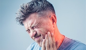Man in pain holding jaw