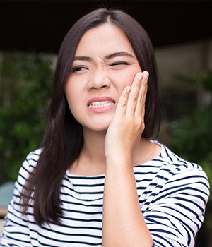 Woman holding jaw in pain