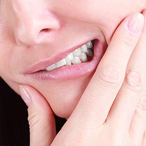 Closeup of person grimacing and holding jaw