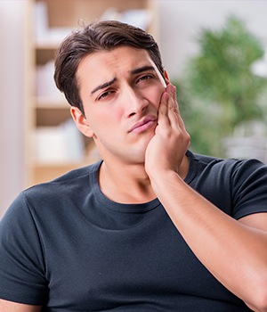 Man holding jaw in pain