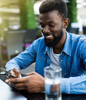 person sitting at a table and looking at their phone