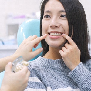 A woman is smiling while being examined by an orthodontist.