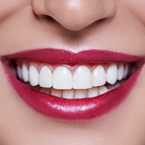 A close up of a woman 's smile with red lips