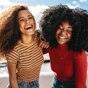 Two women laughing and posing for a picture.