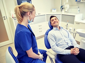 A man and woman sitting in dental chairs.