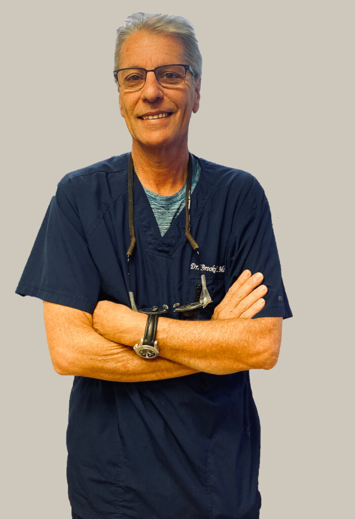 A man in scrubs standing with his arms crossed.