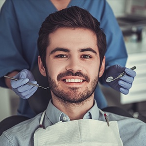 A man getting his teeth checked by an orthodontist.
