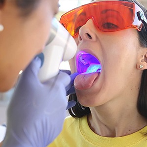 A woman is getting her teeth cleaned by an dentist.