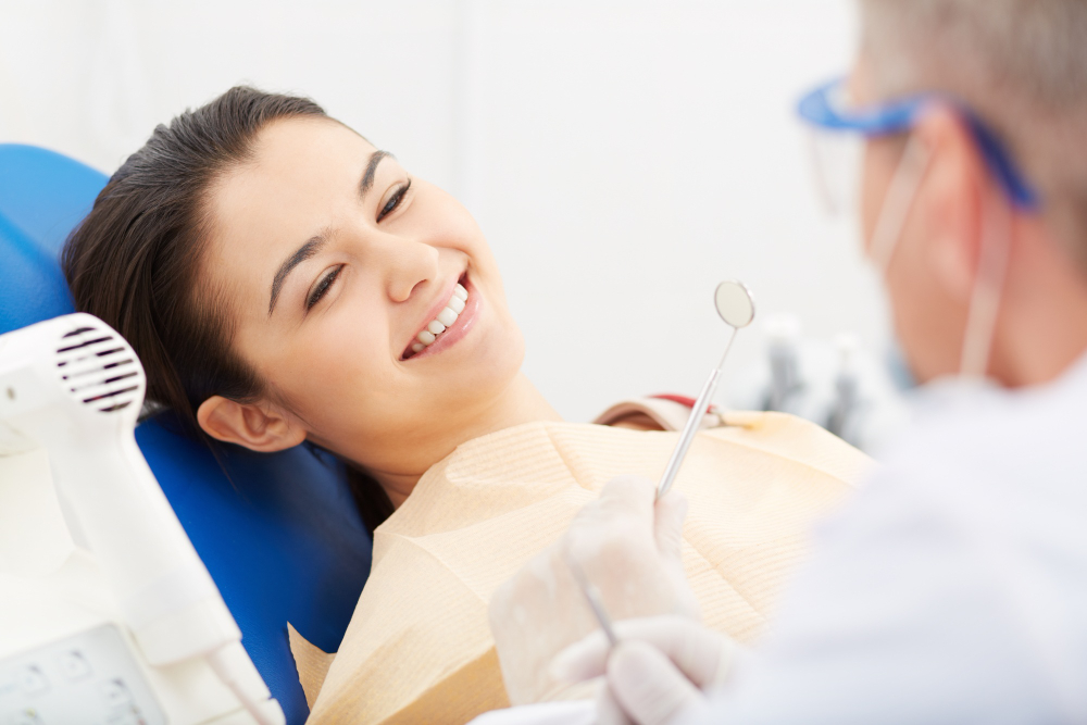 A woman smiling while sitting in the dentist chair.